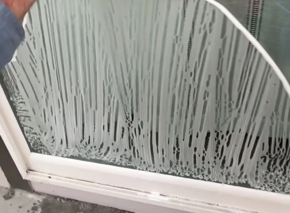 Squeegee cleaning the lower edge of a window above the sill and frame