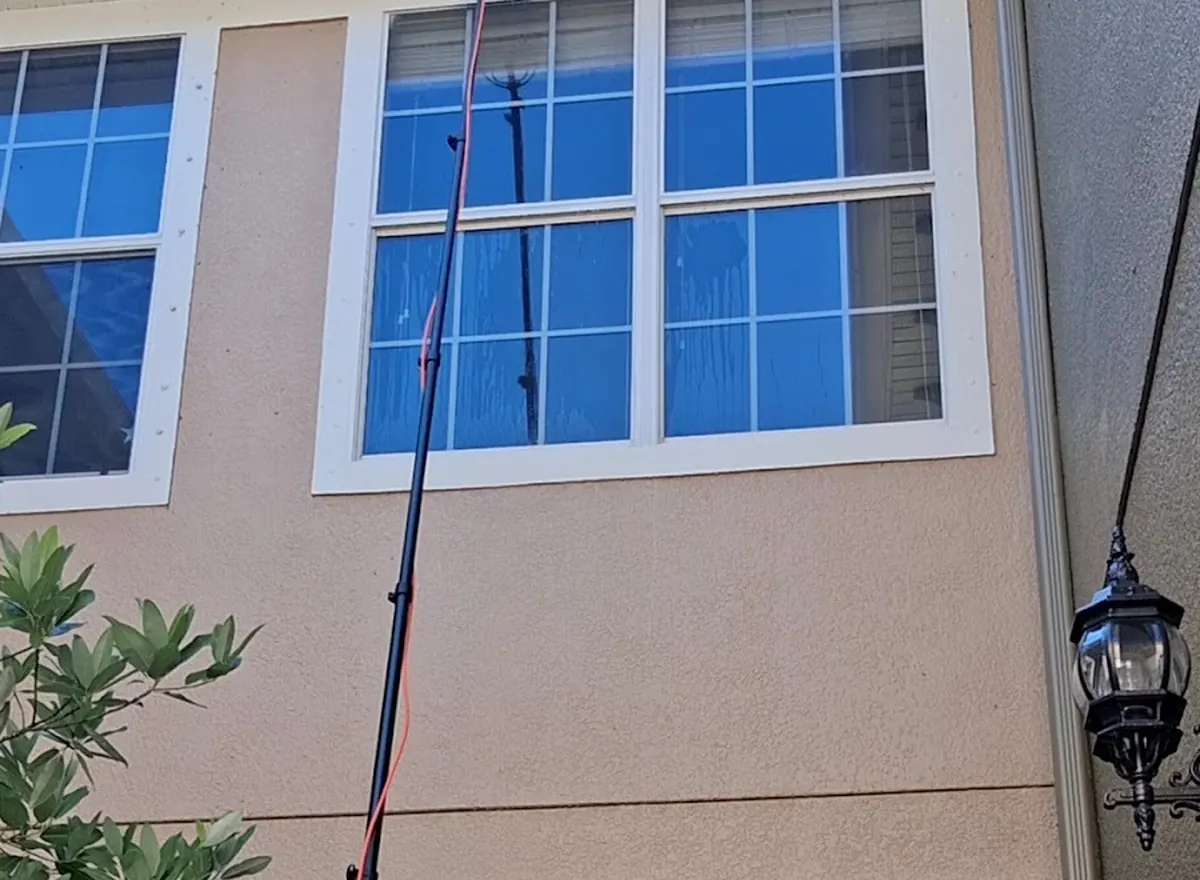 Window washing on the second story of a home using an extension pole